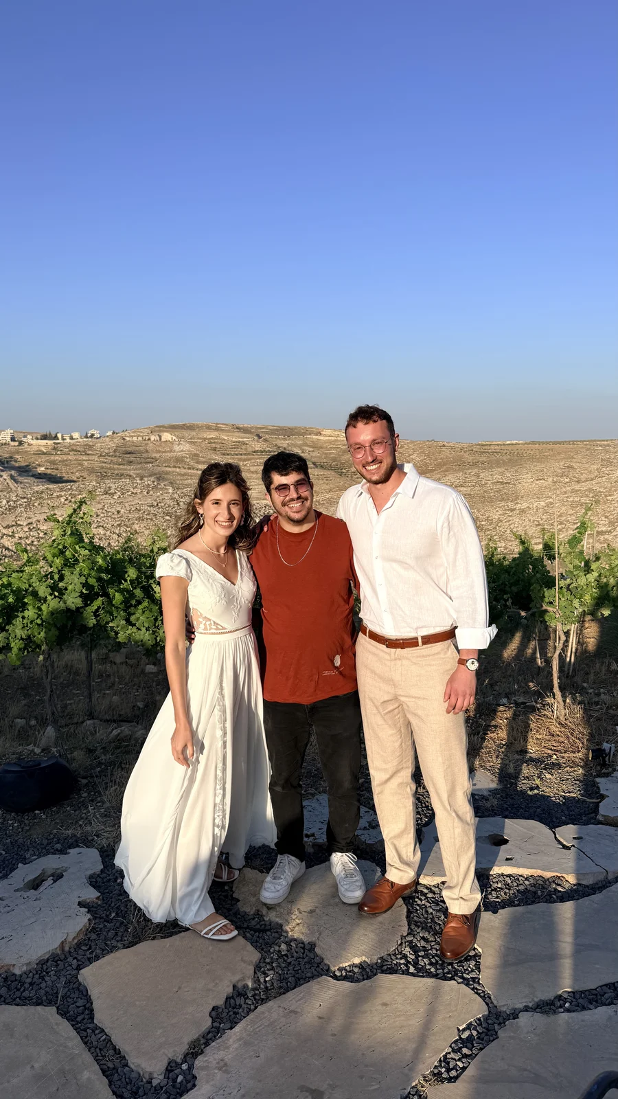 נעמה ואליאור עם אביב ביום החתונה, בחוץ מול נוף פתוח